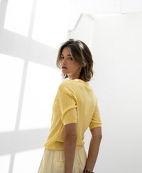Yellow Tencel-silk polo shirt by PLEIN PUBLIQUE shown in sunlight, back and shoulder view.