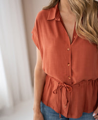 Terra-colored LA JODY blouse by OVERIG with waist tie, highlighting the shape.
