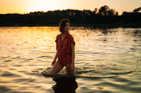 The Terra LA JODY blouse is shown worn outdoors in golden sunset light, surrounded by water and trees.