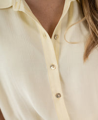 Close-up of soft yellow LA JODY blouse, partly unbuttoned.