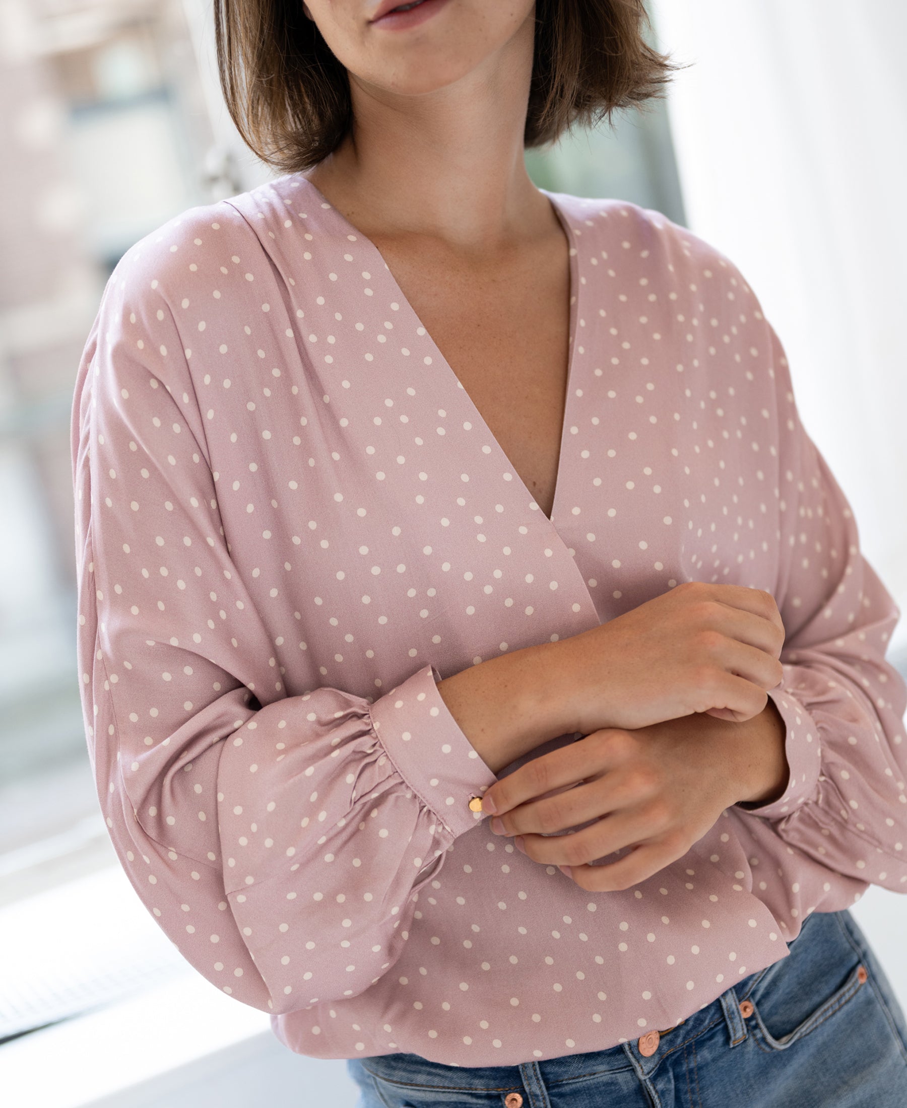 Wrap blouse in dusty pink with ivory dot pattern, shown from the front.