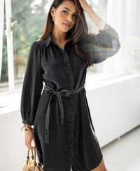 Charcoal Tencel shirt dress in view, shown standing by a window.
