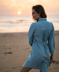 Light blue Tencel blouse dress in a bleached wash, front view, shown outdoors at the beach.