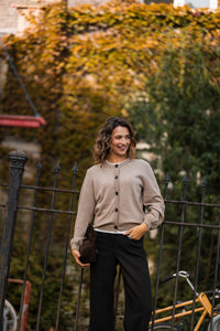 Woman wearing PLEIN PUBLIQUE LA LEA crew neck cardigan in warm taupe with relaxed fit.
