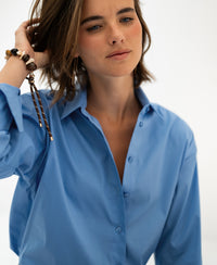 Oversized easy-iron blue blouse in a light setting.