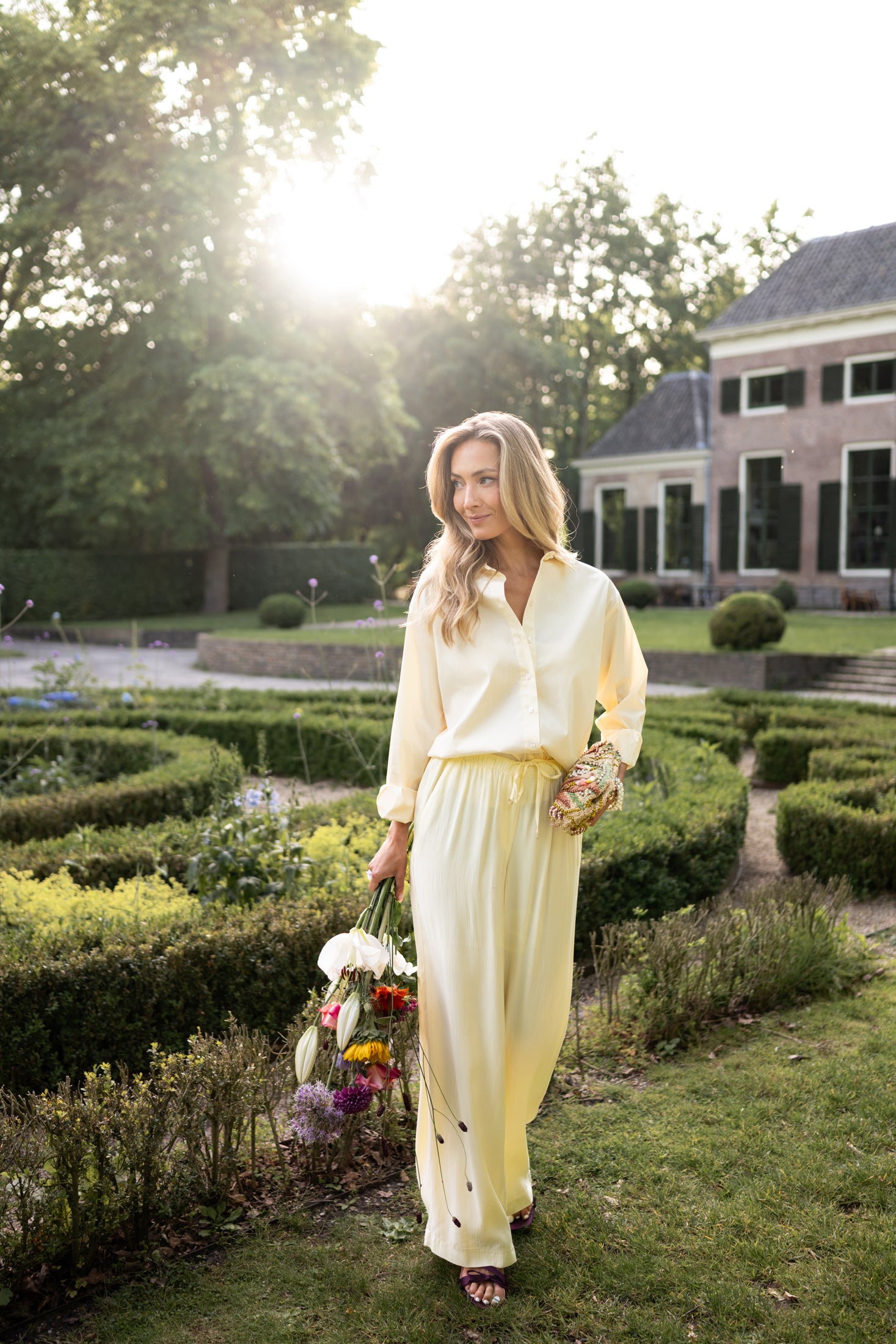 Oversized easy-iron blouse in soft yellow, shown outdoors.