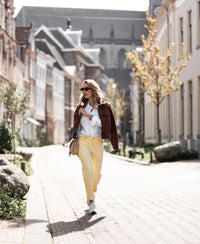 Oversized easy-iron white blouse in a relaxed fit, shown outdoors.