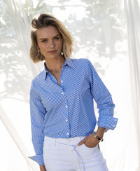 Striped blouse in white and blue worn outdoors in bright sunlight.