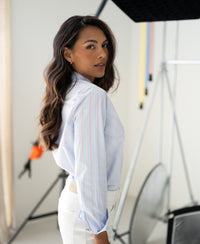 Striped blouse in light blue and coral from PLEIN PUBLIQUE, shown in a studio setting.