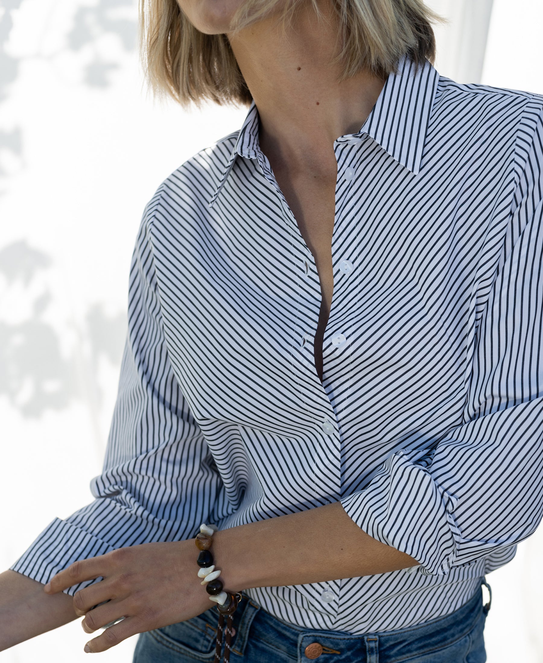 White and black striped LA LOIRE blouse by PLEIN PUBLIQUE with rolled sleeves.