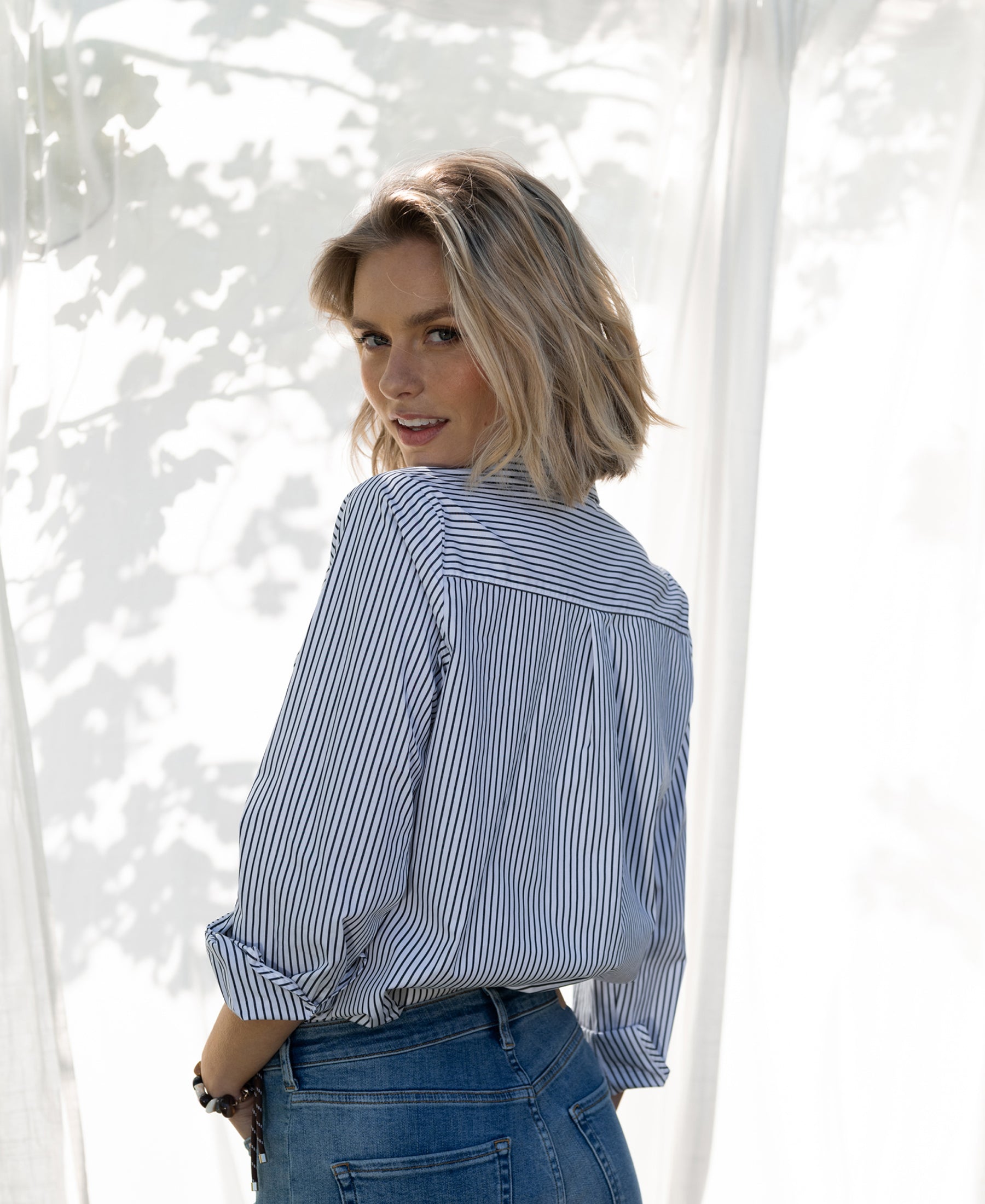 Striped blouse in white and black from Plein Publique, shown worn outside in sunlight.