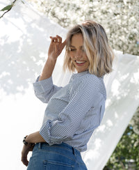 Woman outdoors wearing the PLEIN PUBLIQUE striped blouse LA LOIRE in white and black.