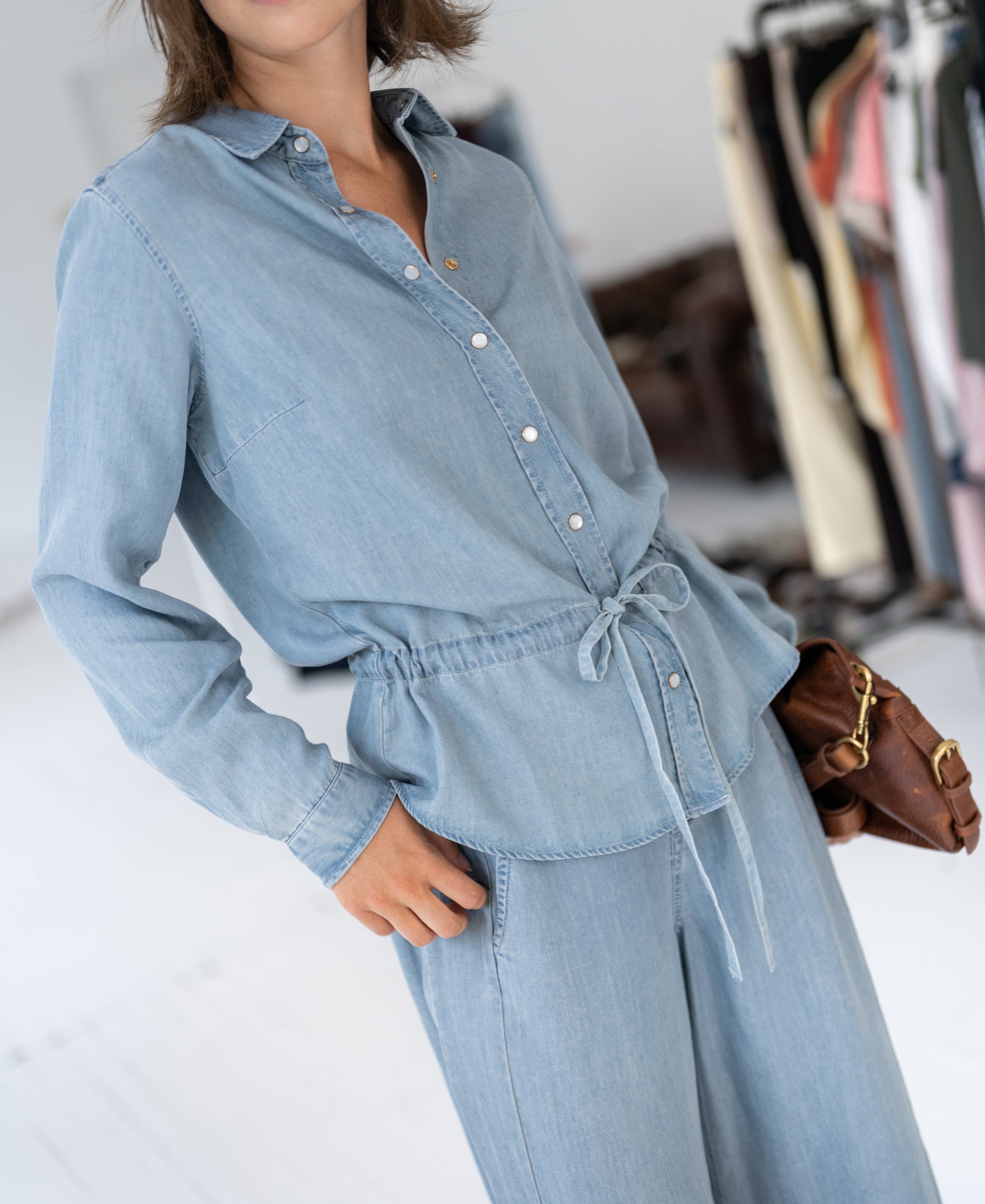Woman wearing bleached Tencel denim blouse, front view.