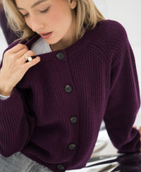 Merino wool vest in Cassis color, front view with model holding the collar and looking downward.