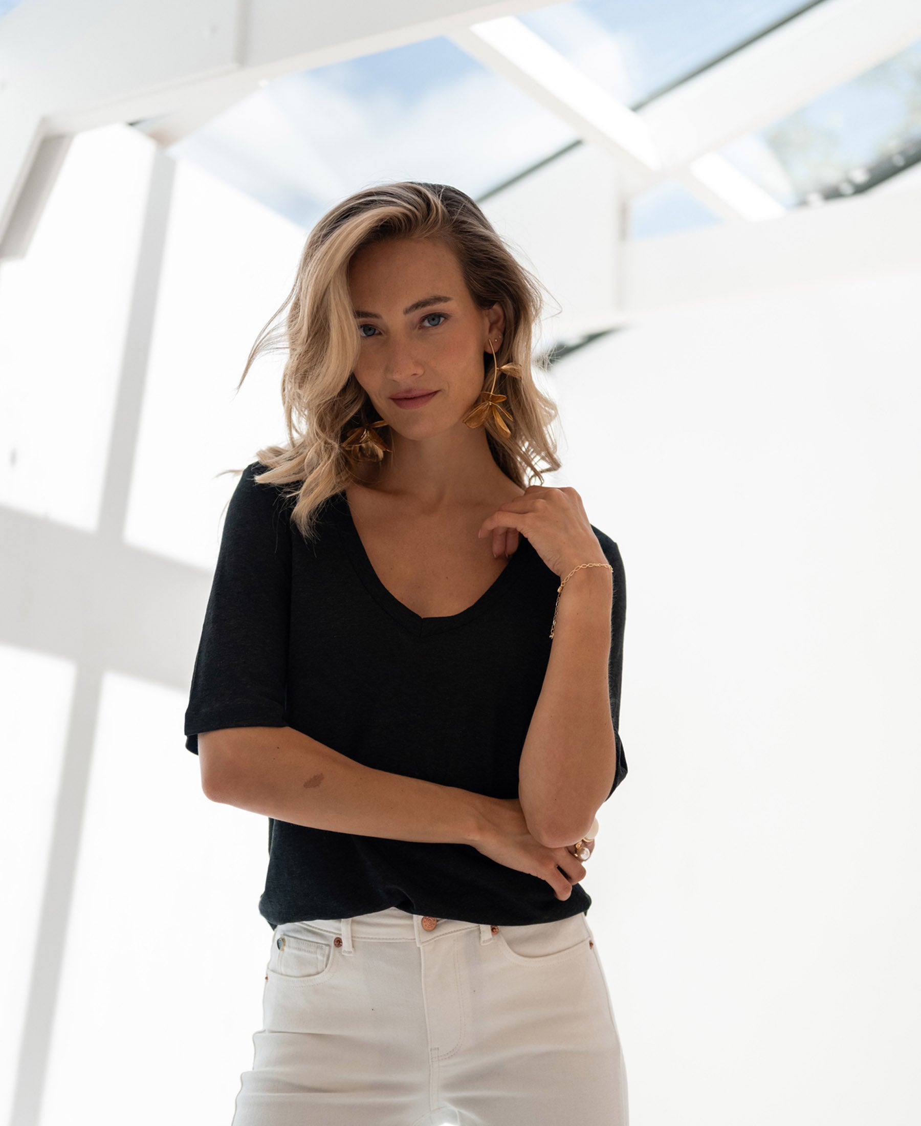 Black linen T-shirt from PLEIN PUBLIQUE, LA DOMI style, shown in a sunlit room.