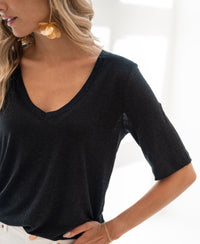 Black linen T-shirt in bright natural light.