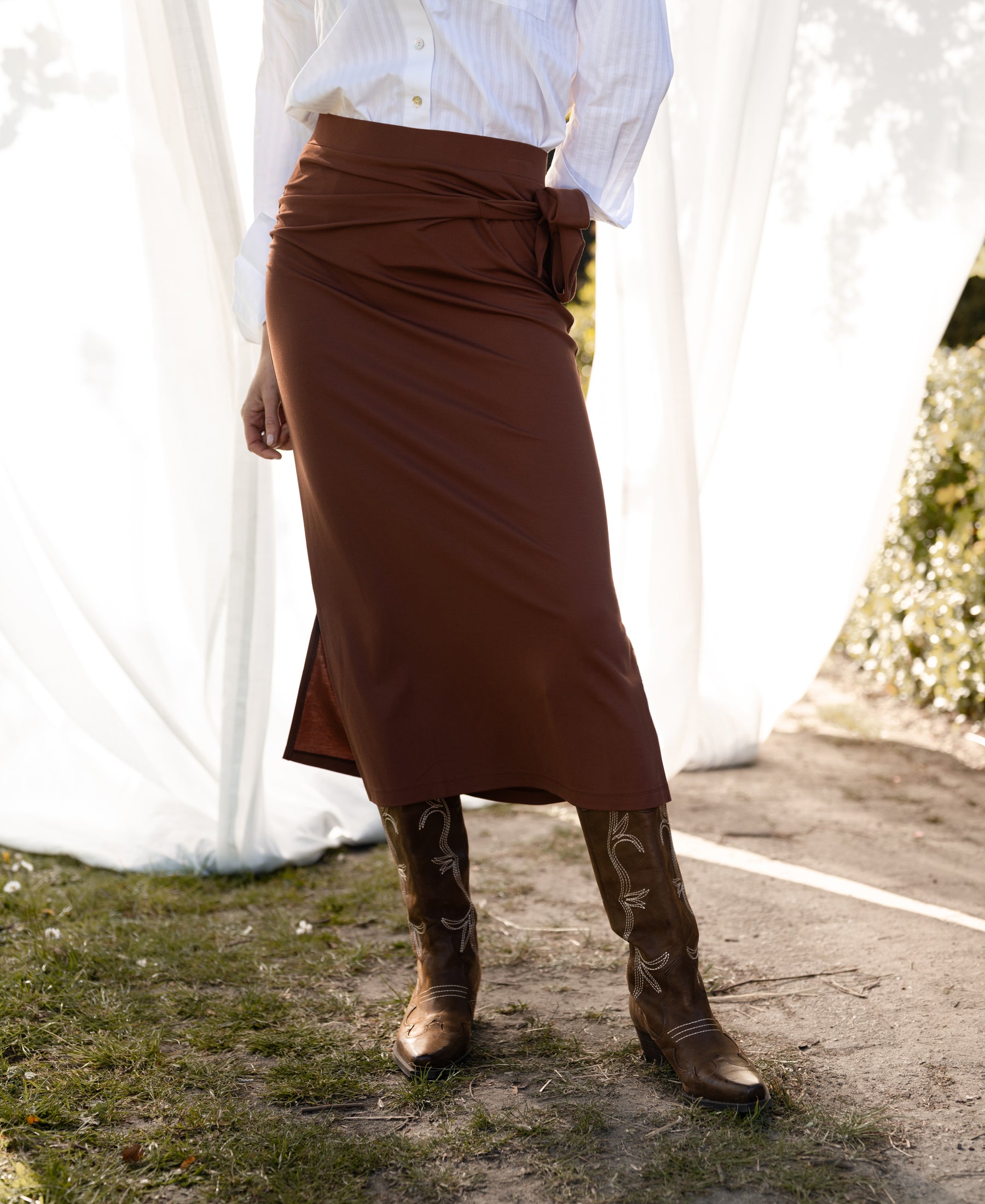 Camel-colored travel skirt LE MAEL by PLEIN PUBLIQUE, shown outdoors on a sunny day.