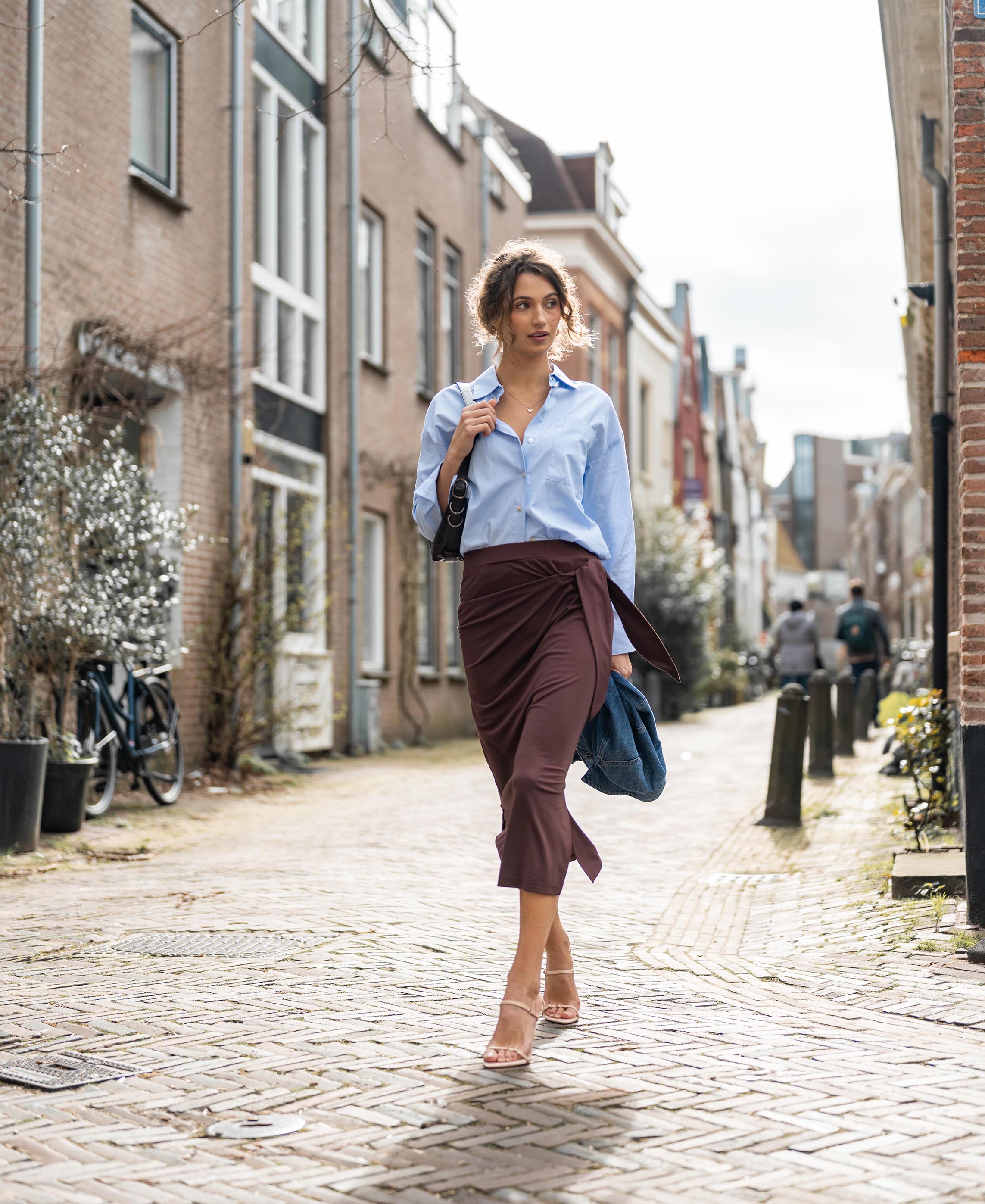 PLEIN PUBLIQUE Travel Skirt LE MAEL in Cacao shown while walking outdoors.