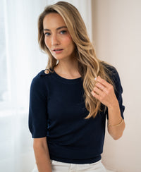 Woman wearing a dark blue Merino wool sweater indoors.