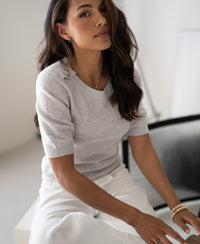 Light grey merino wool sweater, front view, worn by model indoors.