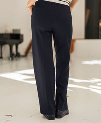 Back view of person indoors wearing navy pinstripe LE MALO trousers by Plein Publique.