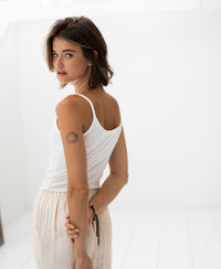 Woman wears PLEIN PUBLIQUE Second Skin Top LE MARAIS White in a bright room.