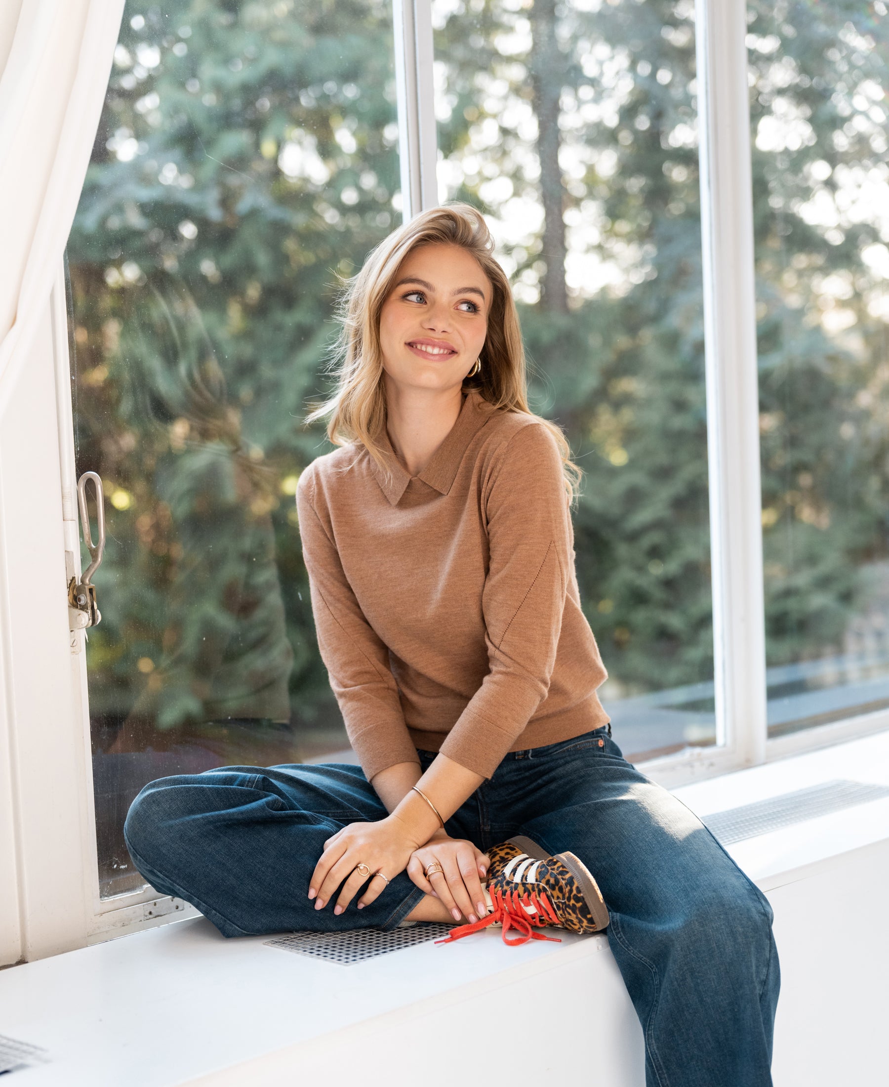 Merino wool polo collar sweater LA MARCEAU in Chai Tea color by PLEIN PUBLIQUE, shown worn near a window.