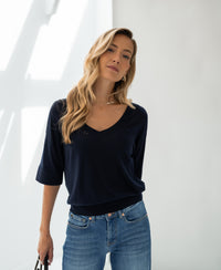 Dark blue silk blend LE MARDY top by PLEIN PUBLIQUE shown on a woman with long blonde hair, indoor setting.