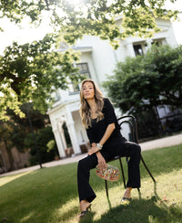 Black silk top by PLEIN PUBLIQUE shown outdoors in sunlight.