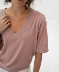Woman wearing a dusty rose silk-blend long-sleeve top.