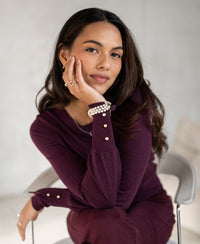 Woman wearing the PLEIN PUBLIQUE Merino wool sweater LA MARIS in Wine-Gold, facing the camera.