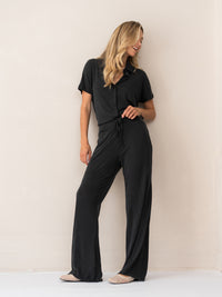 Charcoal lounge pants made from soft fabric, shown from the front against a light-colored wall.