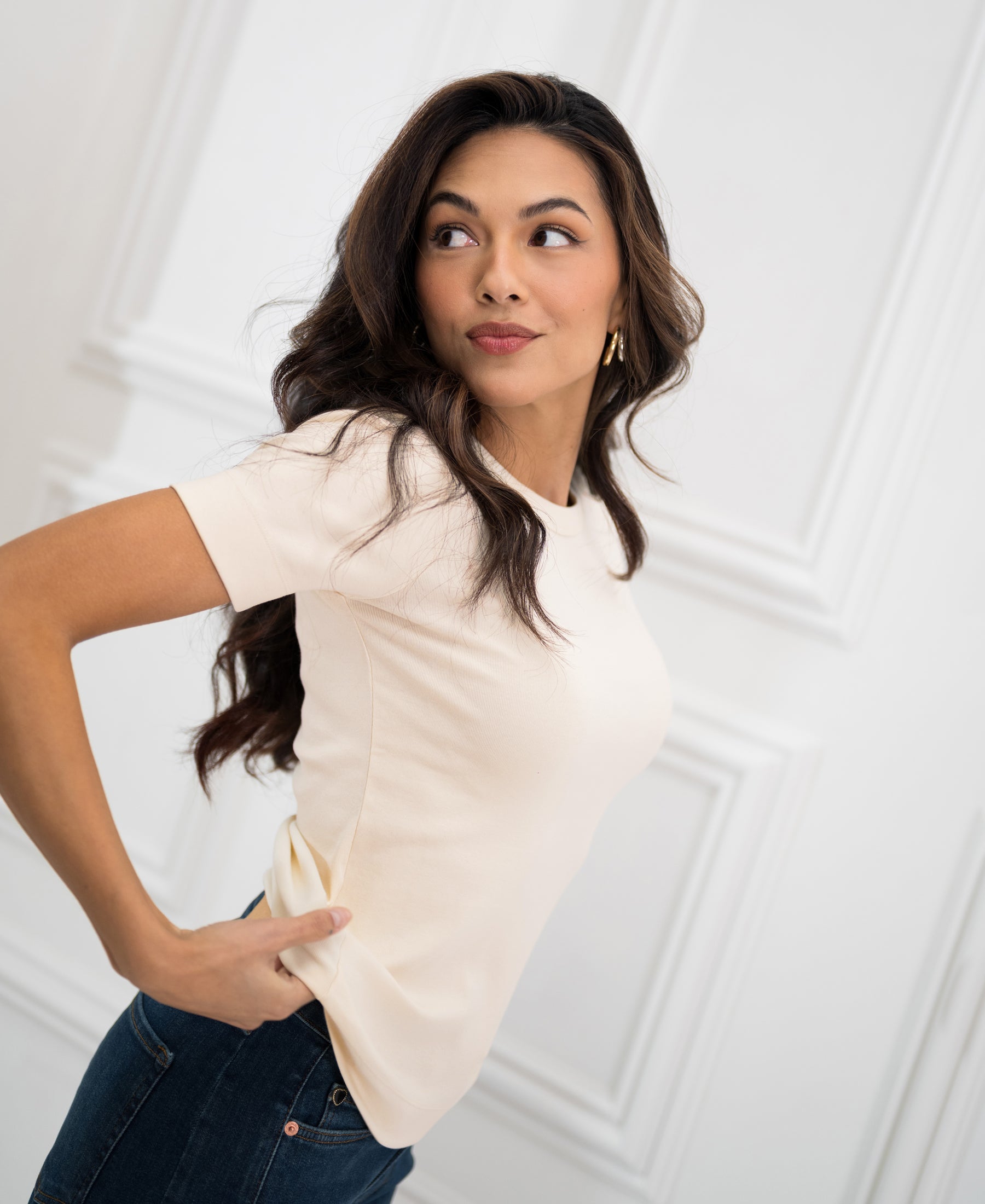 Woman wearing a soft, luxurious butter yellow T-shirt, smiling to the side.