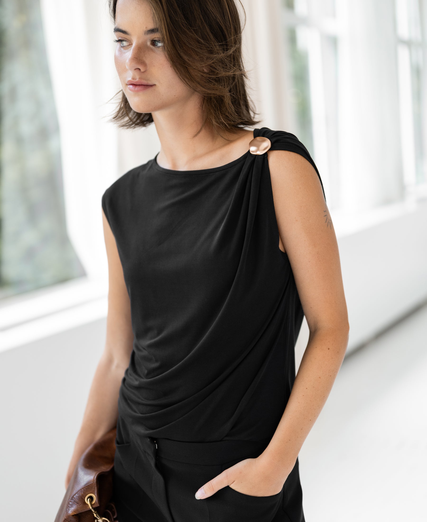 Black LA MAYA top with buckle by PLEIN PUBLIQUE shown worn by a woman.