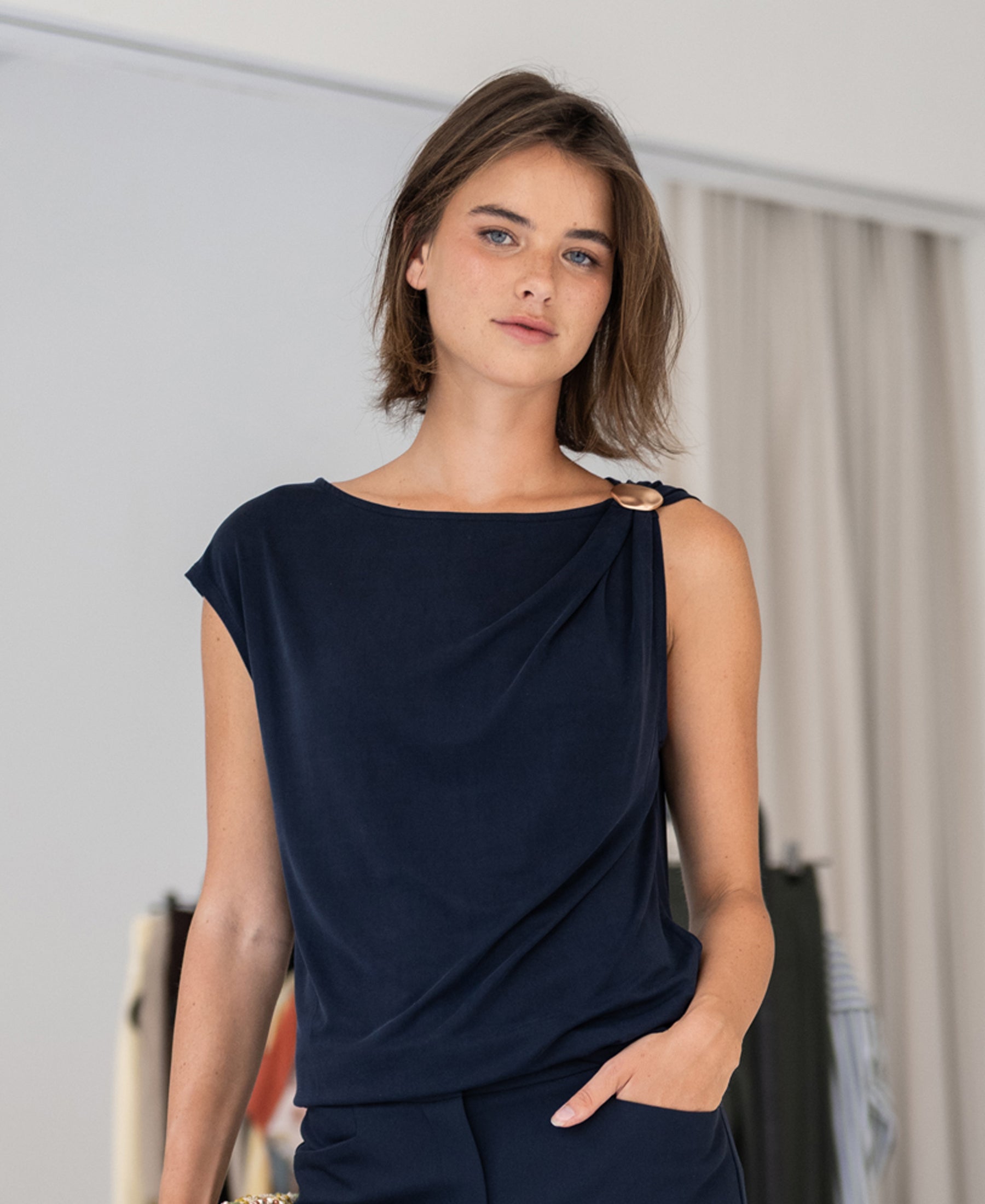 PLEIN PUBLIQUE LA MAYA dark blue top with buckle, shown indoors.