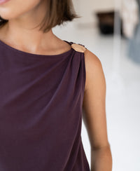 Sleeveless wine-colored LA MAYA top by PLEIN PUBLIQUE with gold buckle detail on the shoulder, neck down view.