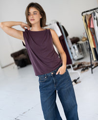 Woman wears the LA MAYA Wine top with clasp by PLEIN PUBLIQUE, shown in a bright room.