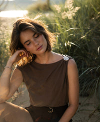 Brown LA MAYA top with buckle by PLEIN PUBLIQUE shown outdoors.