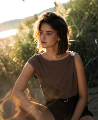 Brown LA MAYA top with buckle by PLEIN PUBLIQUE, shown outdoors.