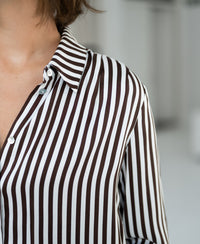Ivory-cocoa striped blouse with tie detail, open collar, and three-quarter sleeves.