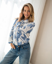 XL blouse with floral print and tie detail, LA MINOU by OVERIG, shown indoors near sheer curtains.