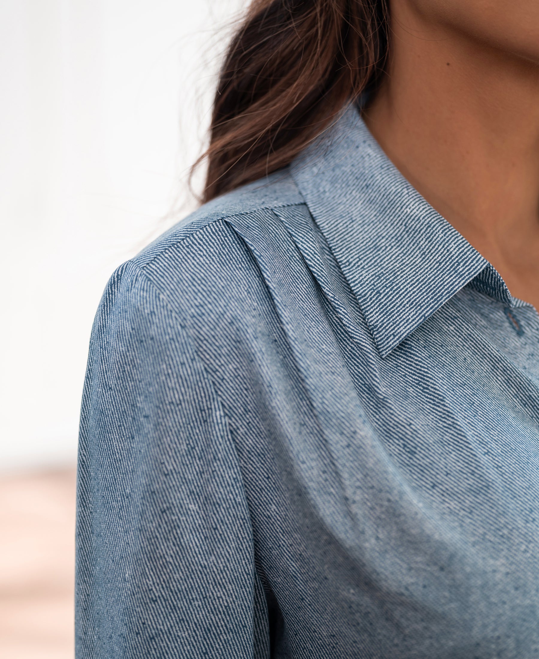 Close-up of the PLEIN PUBLIQUE blouse with tie detail and LA MINOU jeans print.