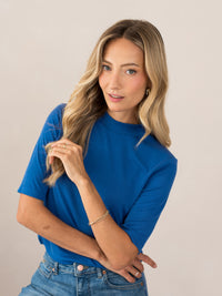 Woman wearing a blue ribbed collared top, LA MIXY Cobalt by PLEIN PUBLIQUE, shown against a plain background.