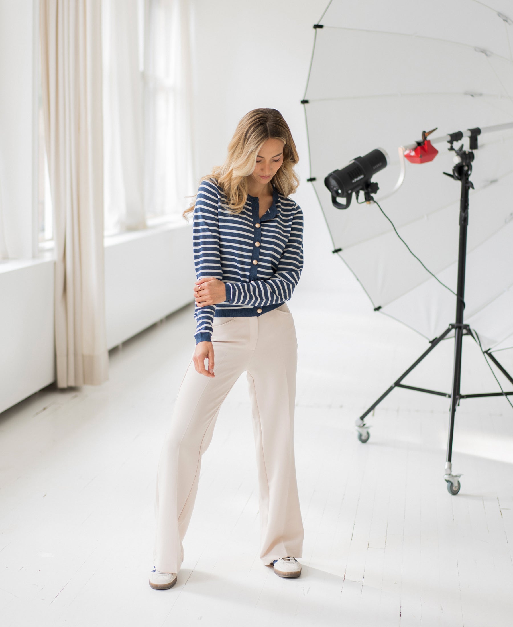 Wide-leg cream pants in a bright studio.