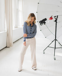 Wide-leg cream pants in a bright studio.