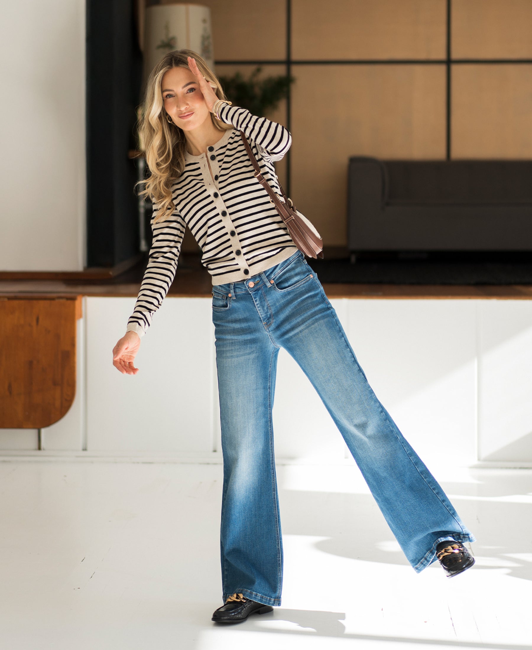 Wide leg jeans in stonewash denim by Plein Publique, modeled indoors with sunlight on the floor.