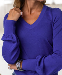 Woman wearing a Plein Publique Merino wool V-neck sweater in Blue Iris.