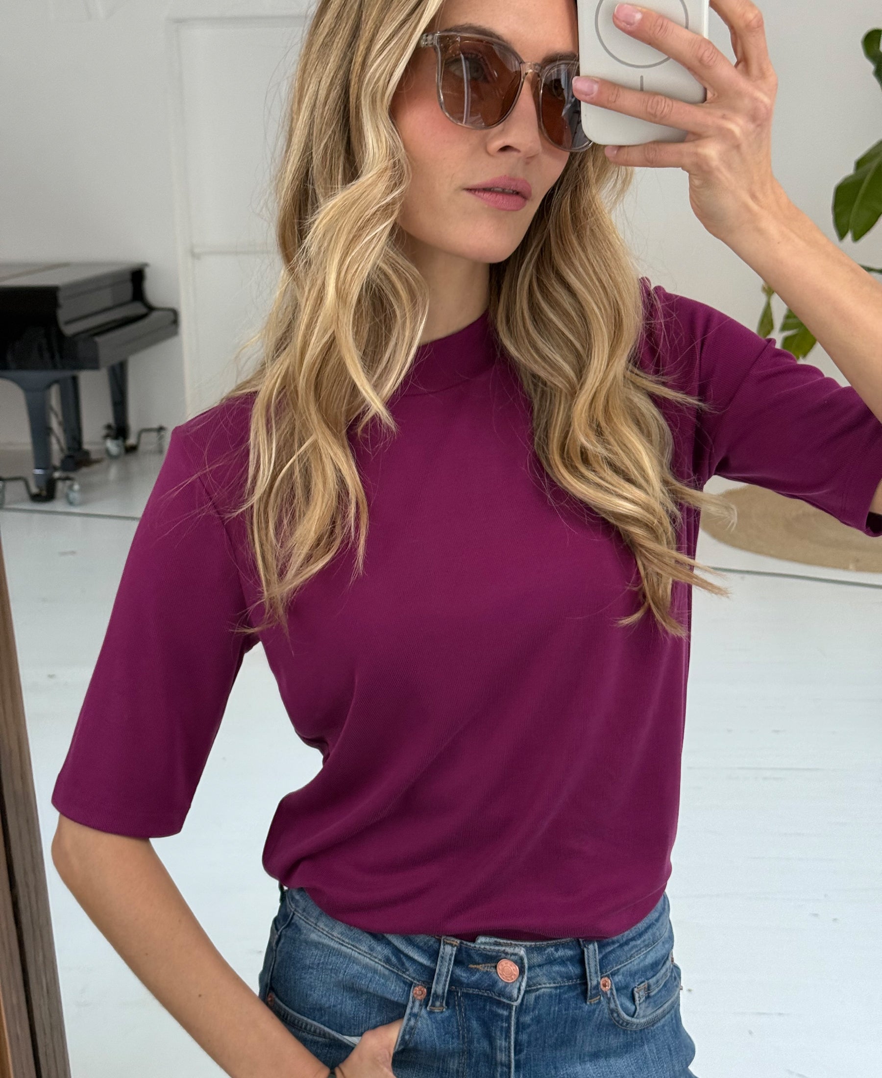 Magenta ribbed collared top in a mirror selfie.