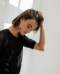 Black mesh sweater with silk, shown in bright sunlight.