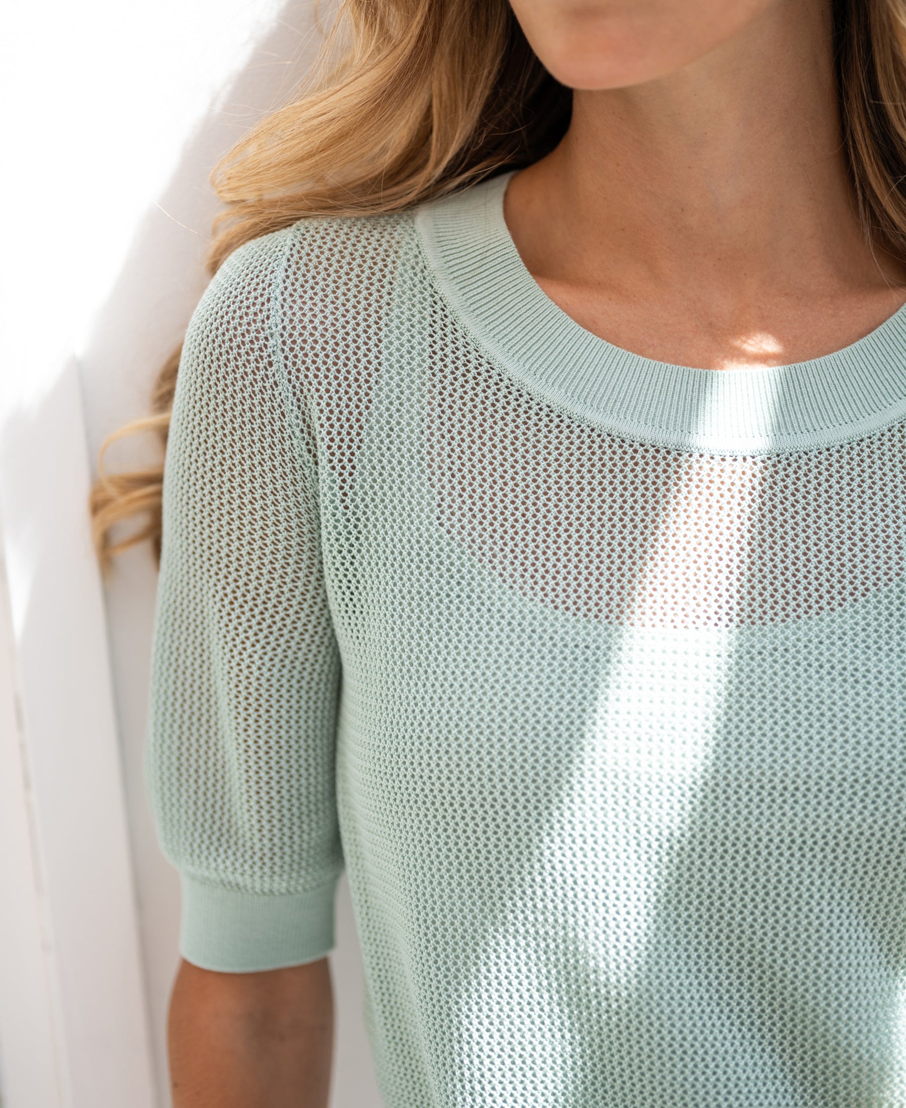 Mesh LE NANCY sweater with silk in mist green by PLEIN PUBLIQUE shown in sunlight.